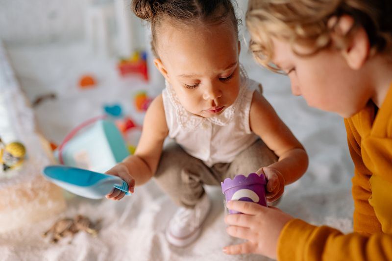 Two children playing together in a sandbox