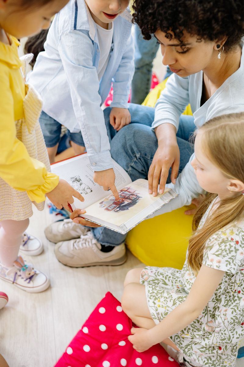 An educator reading a storybook to gathered preschoolers